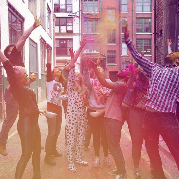 Aimee and group of people throwing colour paint in the air